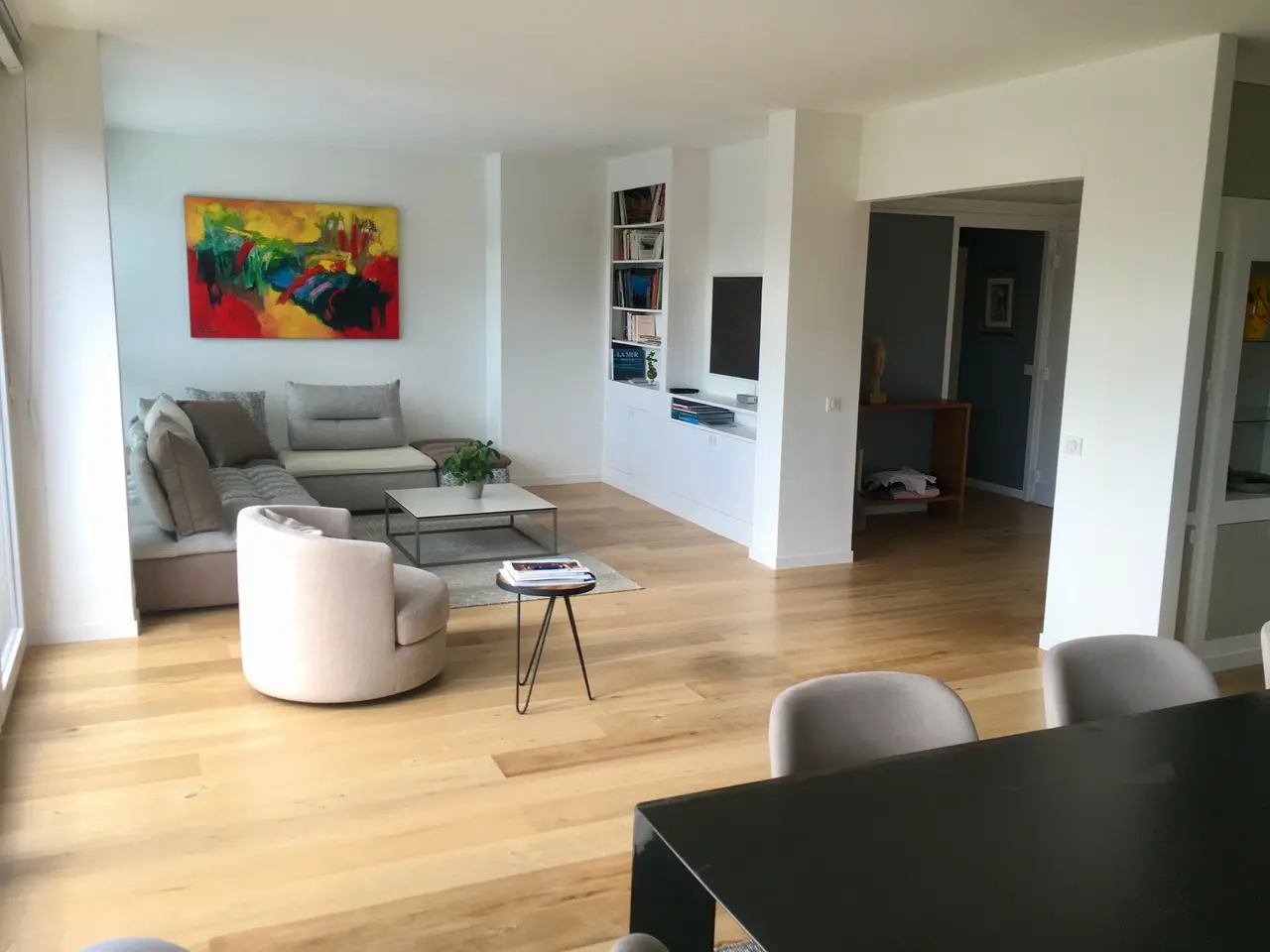 Pièce de vie d’un appartement rénové avec parquet clair et rangements intégrés